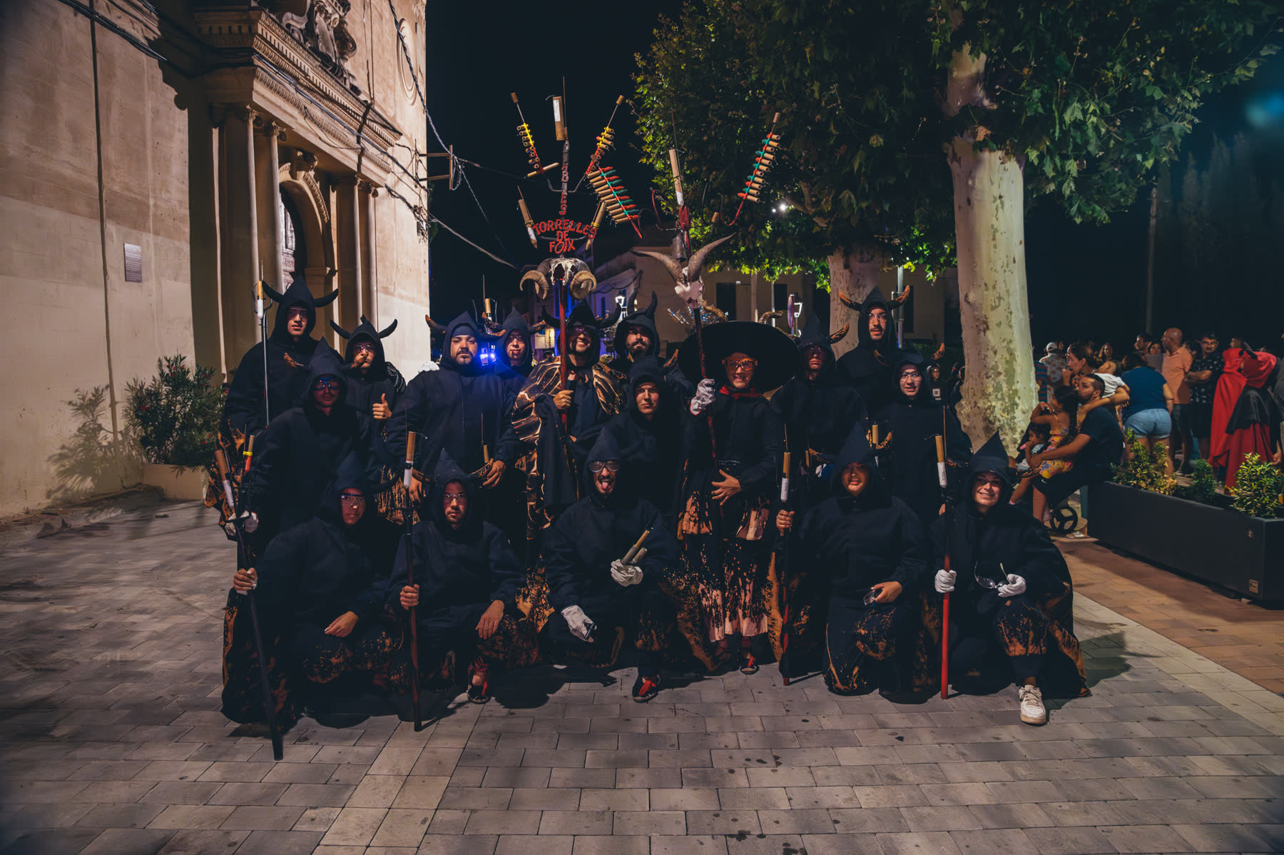 La colla davant l'església amb el ceptrot alçat, nit de correfoc